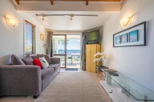 a living room with a couch and a view of the ocean at Palm Beach Cottage with Private Spa Pool & Possibly a Cheap Car to rent in Palm Beach