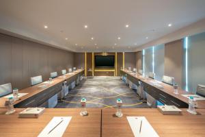 a conference room with long tables and a projection screen at Aber Abha in Abha