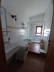 een badkamer met 2 wastafels en een wasmachine bij Casa Sui Tetti in Baunei