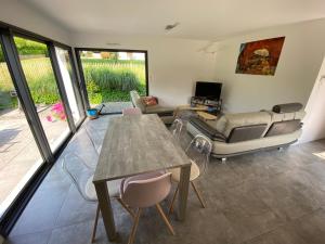 a living room with a table and chairs and a couch at 2 Maisons de vacances Sittelles Lodge in Concarneau