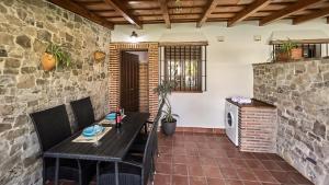 a patio with a table and chairs and a brick wall at Apto El Descanso III Conil de la Frontera by Ruralidays in Conil de la Frontera