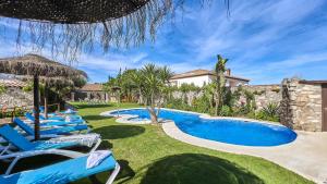 a swimming pool with blue chairs in a yard at Apto El Descanso III Conil de la Frontera by Ruralidays in Conil de la Frontera