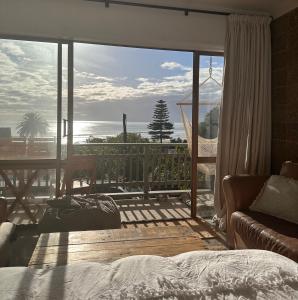 a bedroom with a view of the ocean from a balcony at West End private apartment in Ohope Beach