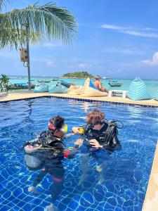 two people in the water in a swimming pool at Lipe Power Beach Resort in Ko Lipe
