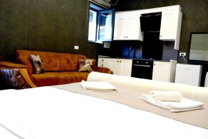a living room with a couch and a table with towels at Arizet Boutique Mamaia in Mamaia
