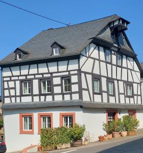 a black and white building with red windows at Romantisches Ferienhaus in Moselnähe in Maring-Noviand