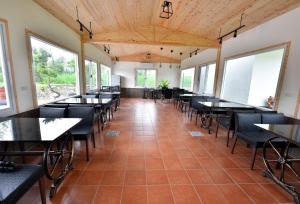 una sala da pranzo con tavoli, sedie e finestre di Leju Diary B&B a Puli