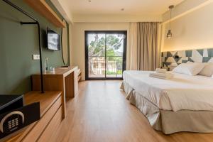 um quarto de hotel com uma cama grande e uma janela em Hotel Santanyi Port em Cala Figuera