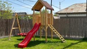a playground with a red slide and a ladder at Bobocel in Sfântu Gheorghe