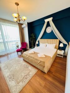 - une chambre avec un lit et un mur bleu dans l'établissement Luxury Studio Mamaia Nord, à Mamaia Nord – Năvodari