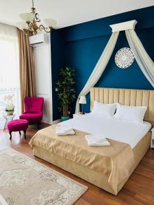 - une chambre avec un lit et un mur bleu dans l'établissement Luxury Studio Mamaia Nord, à Mamaia Nord – Năvodari