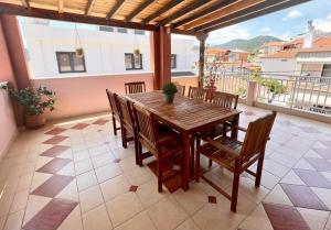 a wooden table and chairs on a balcony at Aurora House in Sarti
