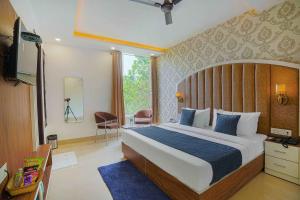 a bedroom with a bed and a television in a room at Hotel Paras in Zirakpur