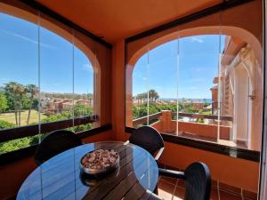 a table and chairs in a room with windows at G&G Premium Los Alamos in Torremolinos