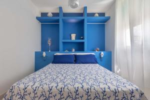 1 dormitorio azul con 1 cama con estanterías azules en Villa Zio Tore by BarbarHouse, en Torre Suda