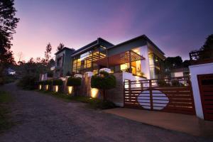 a house with a fence in front of it at night at StayVista at The Yercaud Bungalow with Pvt Pool in Yercaud
