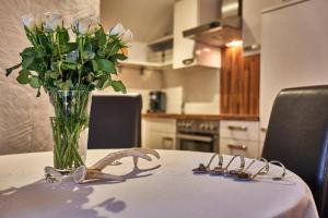 a vase of flowers sitting on a table with a vase of roses at Ferienwohnung Fritz in Bodenmais +34 photos