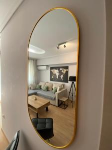 a mirror on a wall in a living room at Spetson Modern 56sqm apt in Piraeus in Piraeus