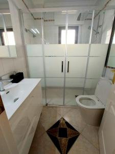 a bathroom with a toilet and a glass shower at Casa Prins 2-bed apartment with stunning views in Ciudad Quesada