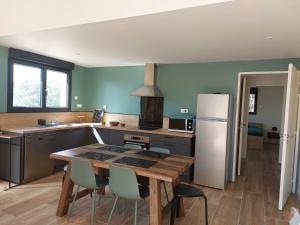 a kitchen with a table and chairs and a refrigerator at La Belle de Cassis in Cassis
