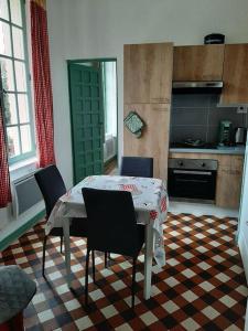 cocina con mesa y sillas en una habitación en Appartement le Vigeant, en Le Vigeant