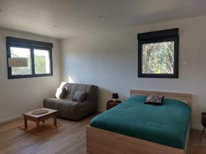 a bedroom with a bed and a couch and a window at La Belle de Cassis in Cassis