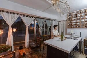 un homme assis à une table dans une cuisine dans l'établissement Spring Day, à Jeonju