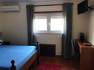 een slaapkamer met een bed, een raam en een bureau bij casa largo do cruzeiro in Peso da Régua