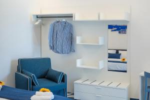 una stanza con una sedia blu e una giacca blu su un muro di Blumare Home a Vico Equense