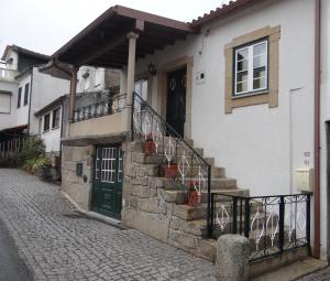 une maison blanche avec une porte et des escaliers verts dans l'établissement Casa Luizinho, à Seixo da Beira