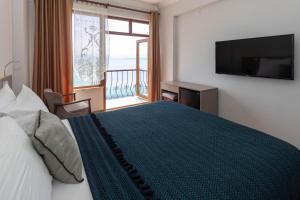 a bedroom with a large bed with a large window at Sinop Antik Otel in Sinop