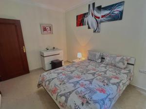 1 dormitorio con 1 cama con colcha colorida en Joli appartement a la corniche de Tanger, en Tánger