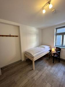 1 dormitorio con cama, mesa y ventana en Gaststätte Brandenburg (Ferienwohnung), en Nordhausen