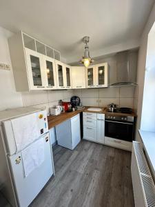 cocina con electrodomésticos blancos y suelo de madera en Gaststätte Brandenburg (Ferienwohnung), en Nordhausen