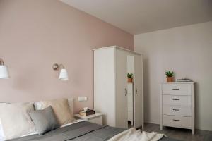 a bedroom with a bed and a white cabinet at Platinum Jaglana Apartment - Wyspa Spichrzów in Gdańsk