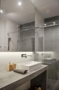 bagno con lavandino e doccia in vetro di Platinum Jaglana Apartment - Wyspa Spichrzów a Danzica