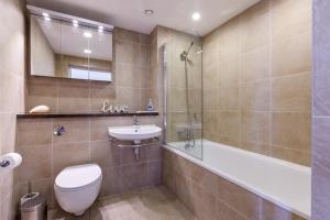 a bathroom with a toilet and a sink and a tub at Carbis Bay and Spa Hotel in St Ives
