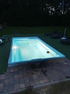 una piscina in un cortile di notte di Apartament u Wioli a Okleśna