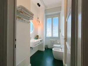 Un baño con lavabo, inodoro y espejo. en [STYLISH FLAT] near station and city center, en Como