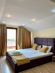 a bedroom with a large bed with a large window at Apartament Central in Constanţa