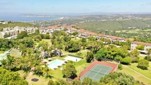 uma vista aérea de uma casa com um campo de ténis em Castleton Self-Catering Accommodation em Plettenberg Bay