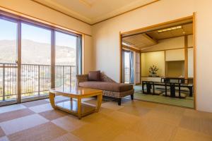 a living room with a couch and a table at Japanese Onsen Ryokan Kohakuen in Fuefuki