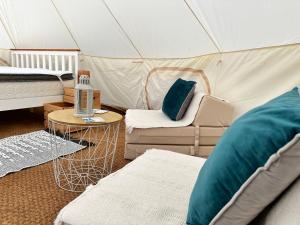 Habitación con tienda de campaña, cama y silla en RosaBell Bell Tent at Herigerbi Park en Lincolnshire