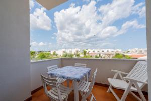 einen Balkon mit einem Tisch und Stühlen sowie Stadtblick in der Unterkunft Casa Chanty by Rentbeat in Ostuni