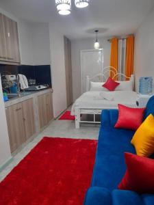 ein Wohnzimmer mit einem Bett und einer blauen Couch in der Unterkunft Lux Suites Tsavo Studios Embakasi in Nairobi