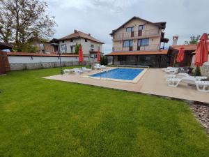 a backyard with a swimming pool and a house at Къща за гости - Вила Сидона in Banya