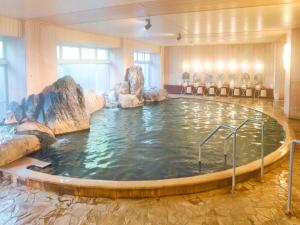 una grande piscina d'acqua in una stanza con rocce di Ooedo Onsen Monogatari Hotel New Shiobara a Nasushiobara