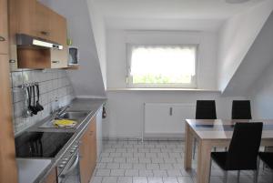 a kitchen with a sink and a table and a window at Ferienwohnungen am Plätlinsee in Wustrow