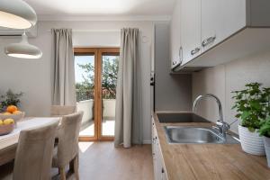 a kitchen with a sink and a table with chairs at Apartments Alloro by SeeAdria Agency in Novigrad Istria +156 photos