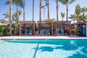 una piscina con sedie blu e palme di The Dixie Hollywood a Los Angeles